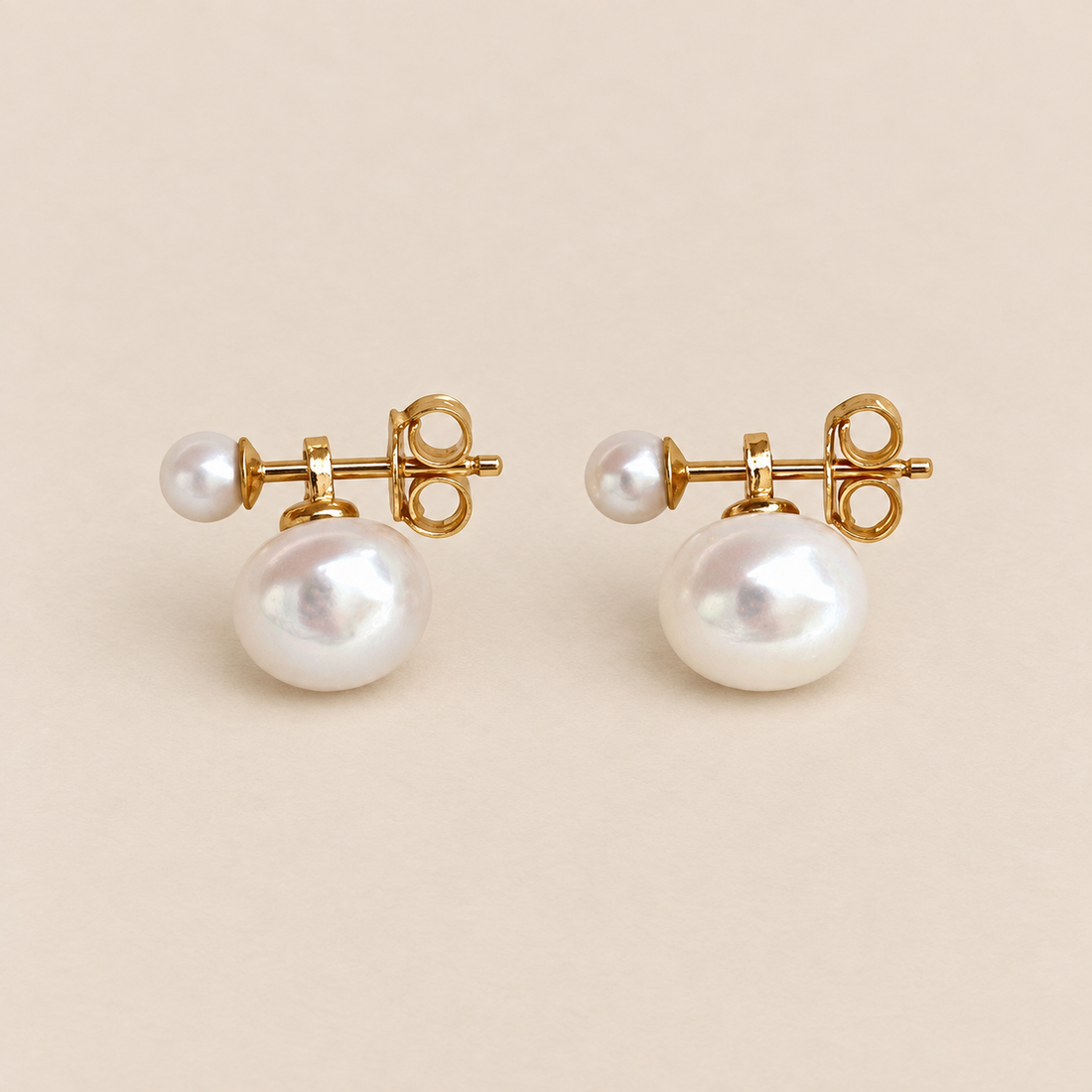 Lucie 18K Gold-Plated Double Pearl Studs on a warm beige background