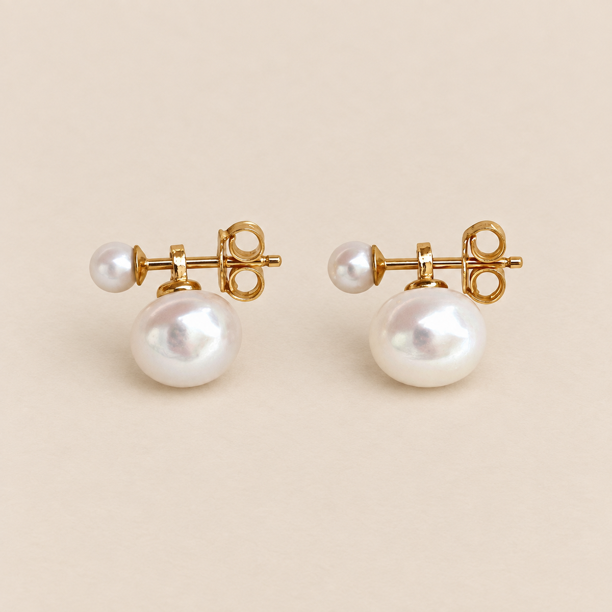 Lucie 18K Gold-Plated Double Pearl Studs on a warm beige background